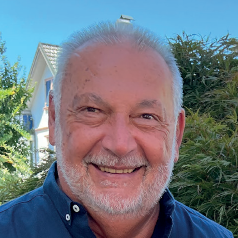 Ein lächelnder Mann mit Bart.