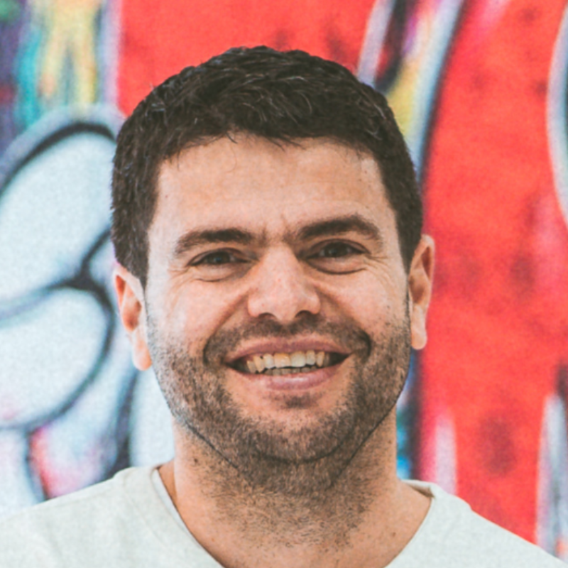 Ein lächelnder Mann mit Bart.