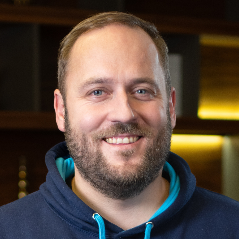 Ein lächelnder Mann mit Hoodie.