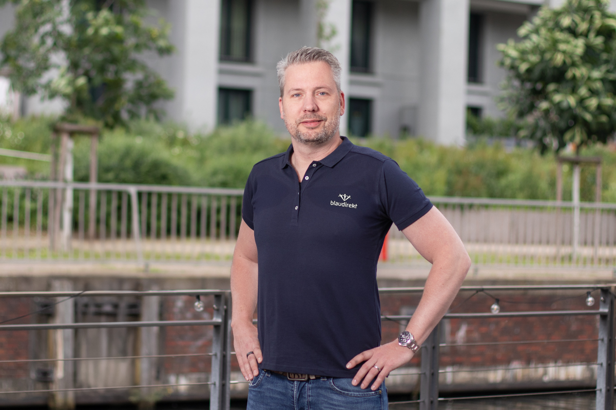 Mann im blau direkt Poloshirt lächelt in die Kamera