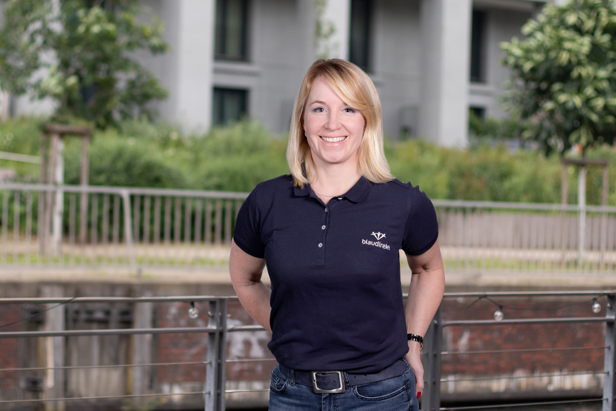 Blonde Frau im blau direkt Poloshirt lächelt in die Kamera